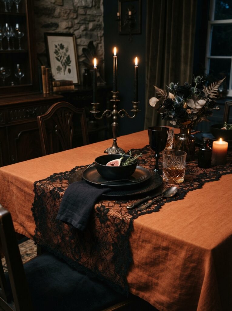 ![A dining table featuring a solid burnt-orange linen tablecloth overlaid with an intricate black lace runner, set with black ceramic plates, moody evening lighting, vertical Pinterest photography, gothic Victorian dining styling.]