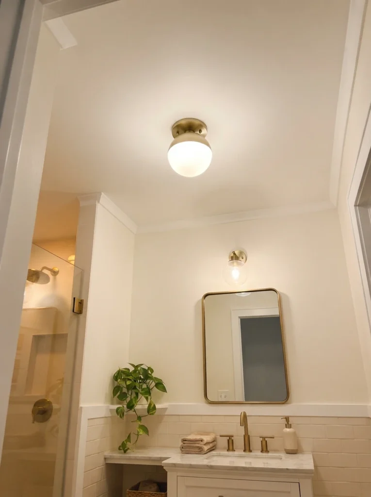A smooth, freshly painted ceiling in a small bathroom, replacing a dated popcorn texture, warm bathroom lighting, vertical Pinterest photography, warm smooth-ceiling styling.