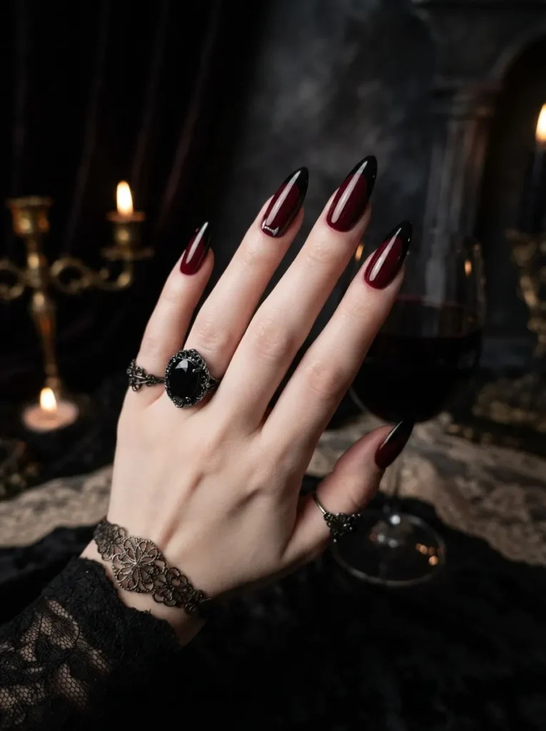 ![Gothic vampire Halloween nails in glossy black and deep burgundy red, subtle fang details, red French tips, dramatic evening manicure, vertical Pinterest photography.]